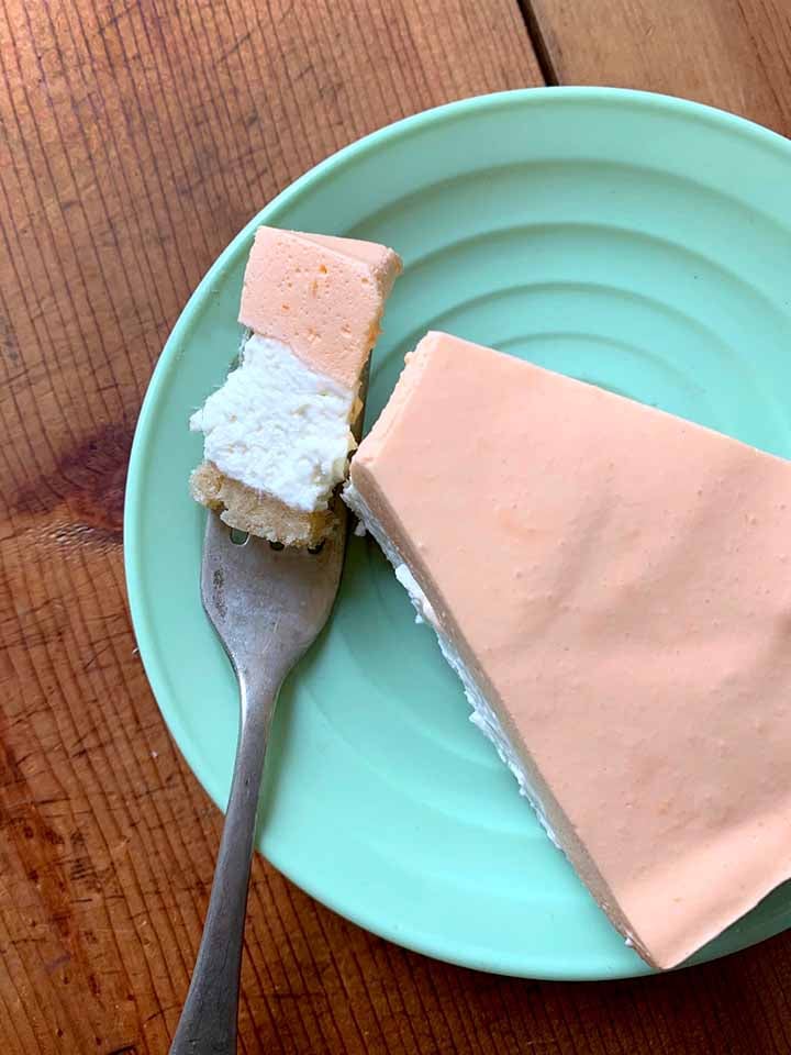 a top down view of a slice of gluten free creamsicle cheesecake with a fork