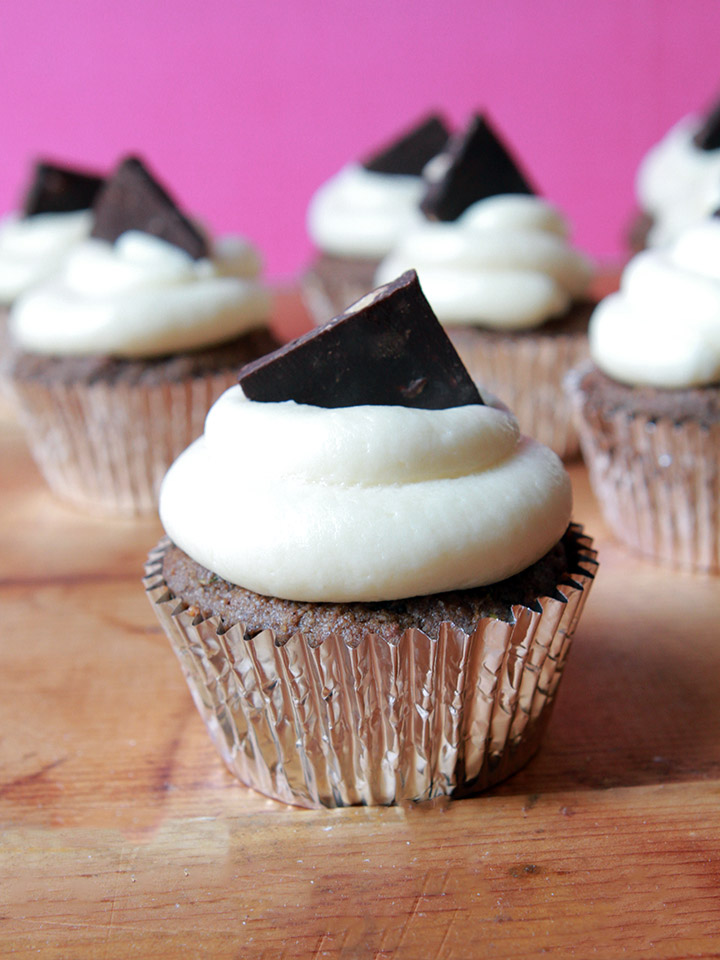 a group of low carb chocolate cupcakes against a pink background