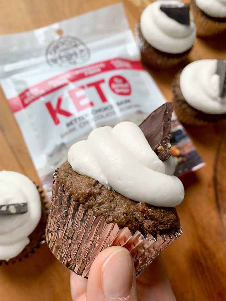 a hand holds a sugar-free chocolate almond bark cupcake