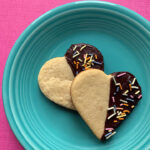 Two Keto heart shaped shortbread cookies on a blue plate