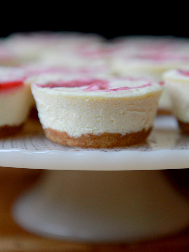 a close up shot of a berry swirl low carb mini cheesecake on a plate