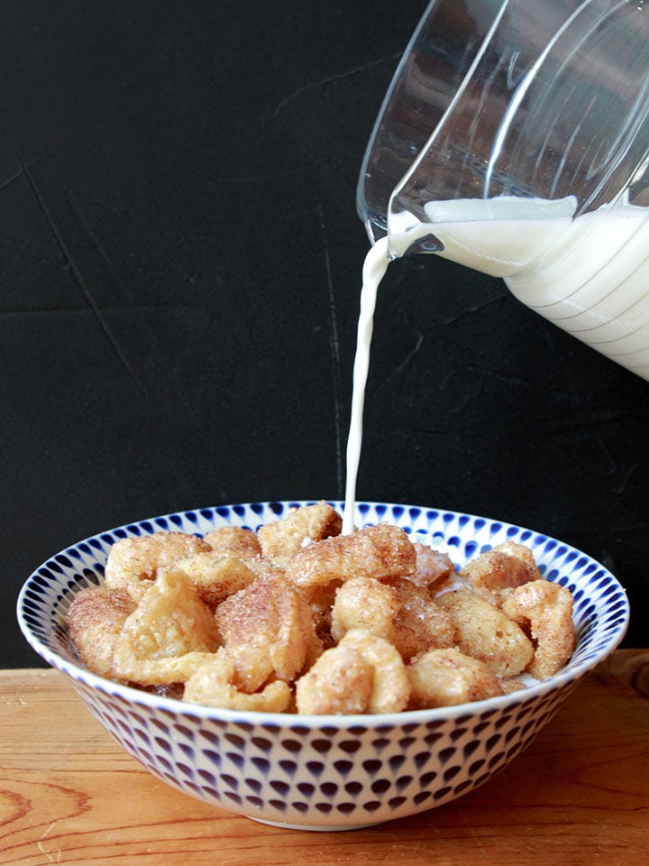 a pitcher pours milk over a bowl of Keto Cinnamon Toast Crunch cereal