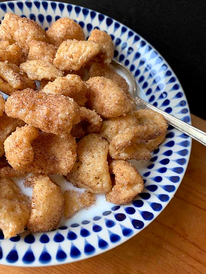a side view of a bowl of low carb cereal with a spoon in it