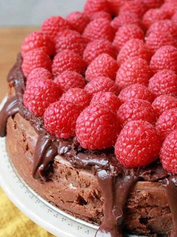a Keto chocolate cheesecake topped with fresh raspberries