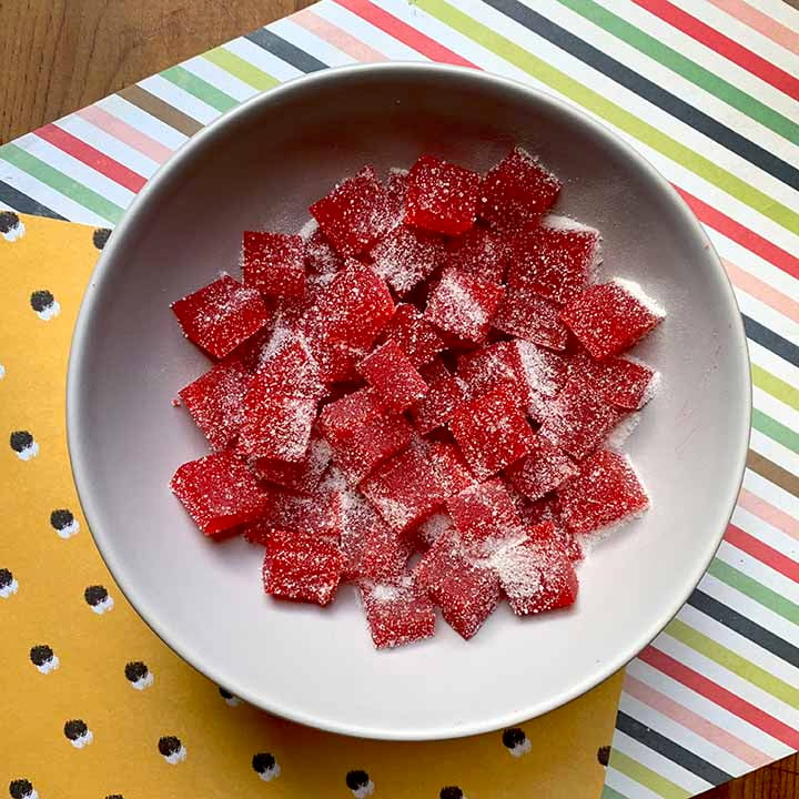 a top down shot of a bowl of healthy homemade gum drops against brightly colored paper