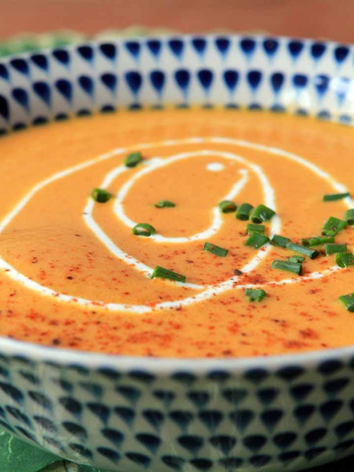 a side view of a bowl of creamy vegetarian carrot soup
