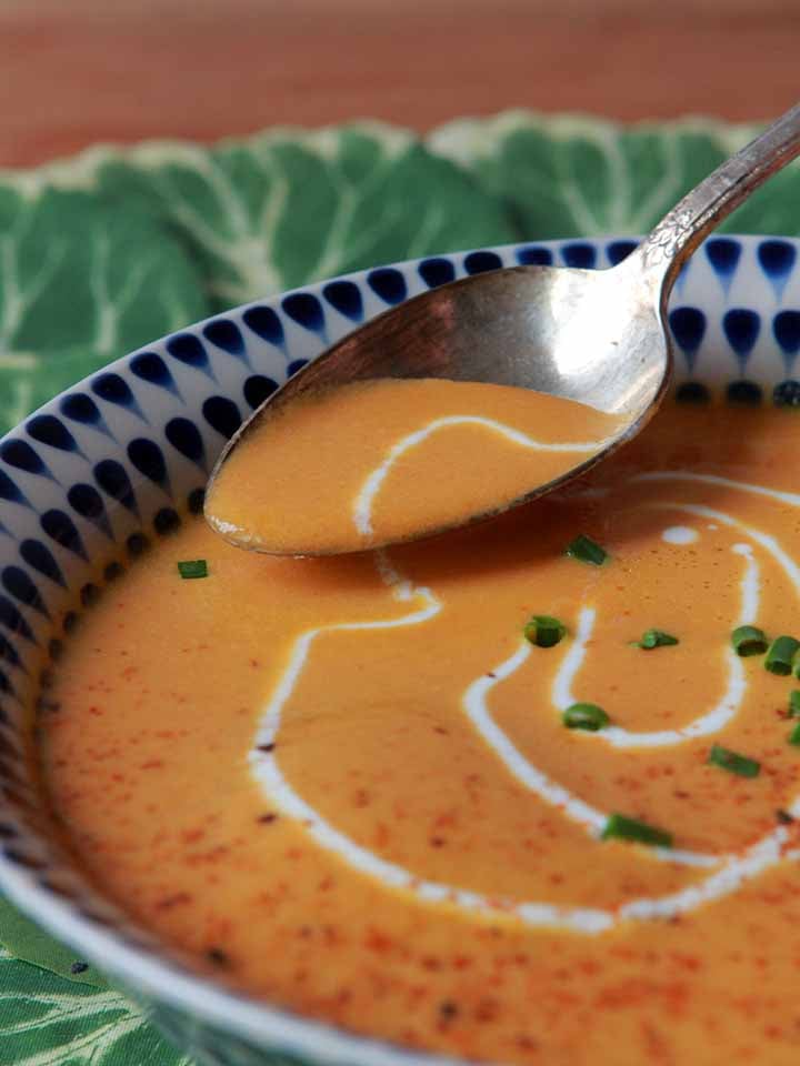 A spoon scoops up a bit of Keto Carrot Coconut Soup