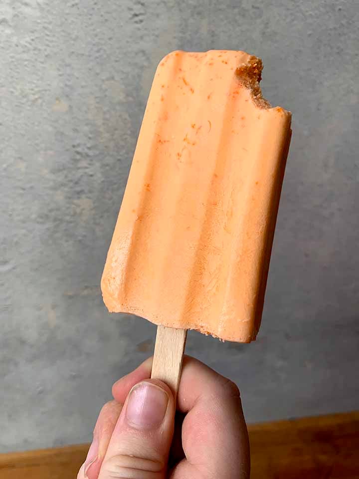a child's hand holds a sugar-free creamsicle
