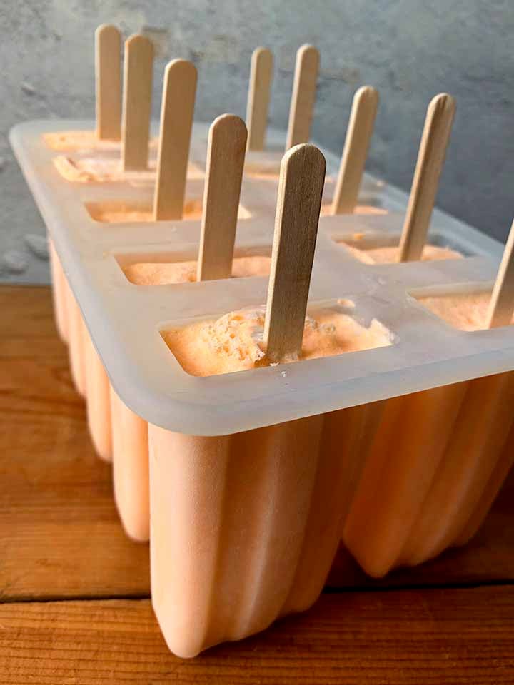 8 sugar0free orange popsicles in a popsicle mold