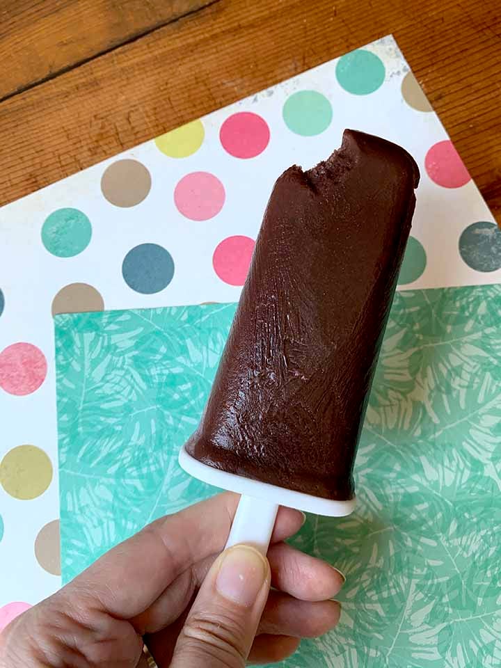 a hand holds a sugar-free chocolate pudding pop