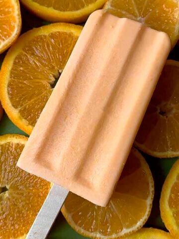 a Keto orange creamsicle against a background of oranges
