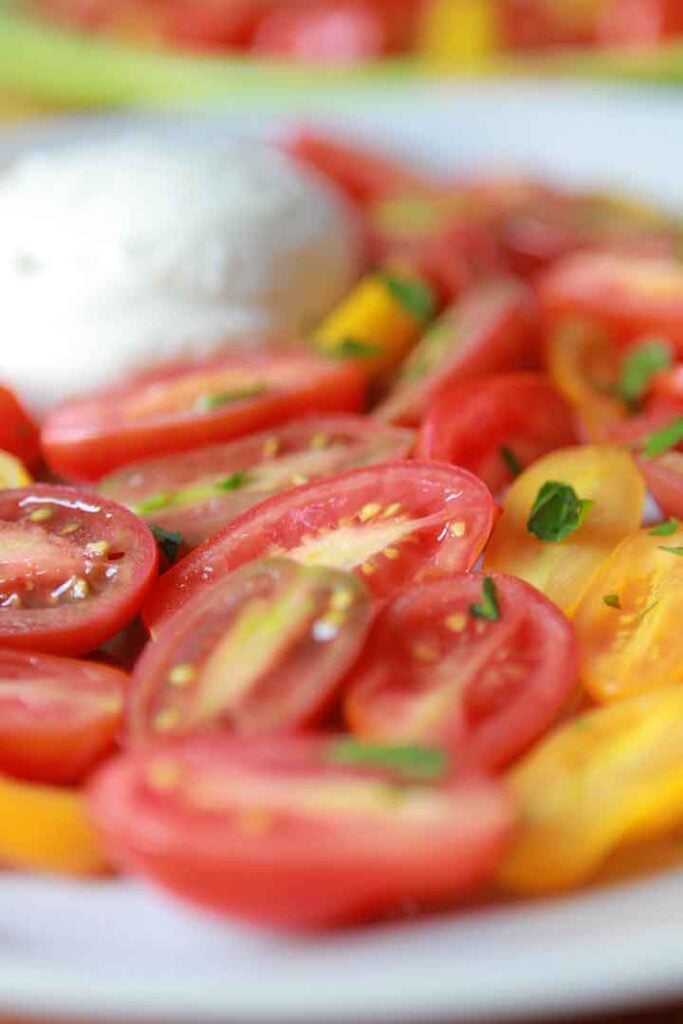 a close up of sliced grape tomatoes and buffalo mozzarella balls