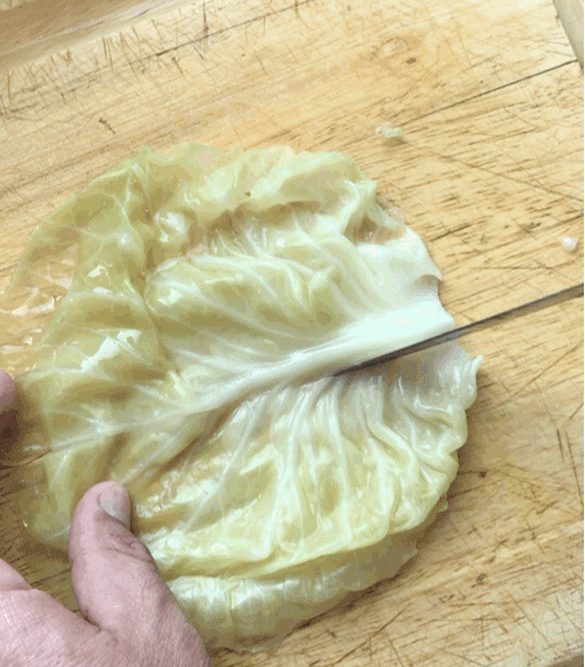 a gif showing how to cut the stem out of a cabbage leaf for cabbage dumplings