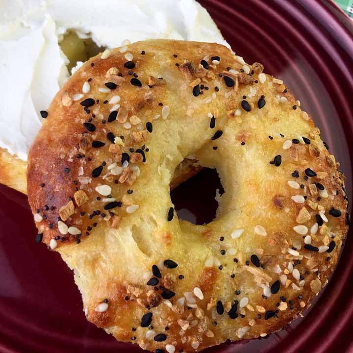 a sliced keto everything bagel with cream cheese