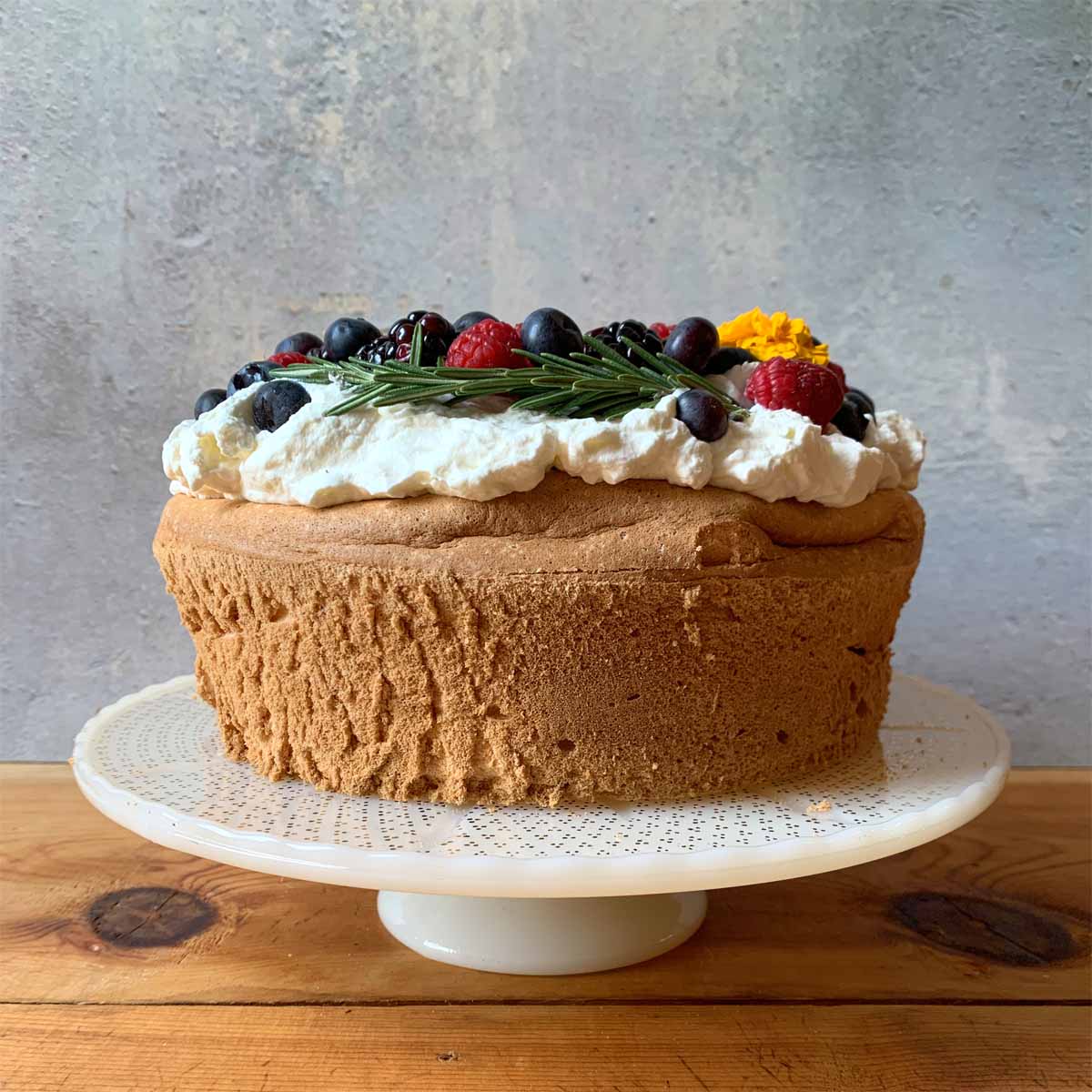 a side view of a Keto Angel Food Cake on a cake pedestal 