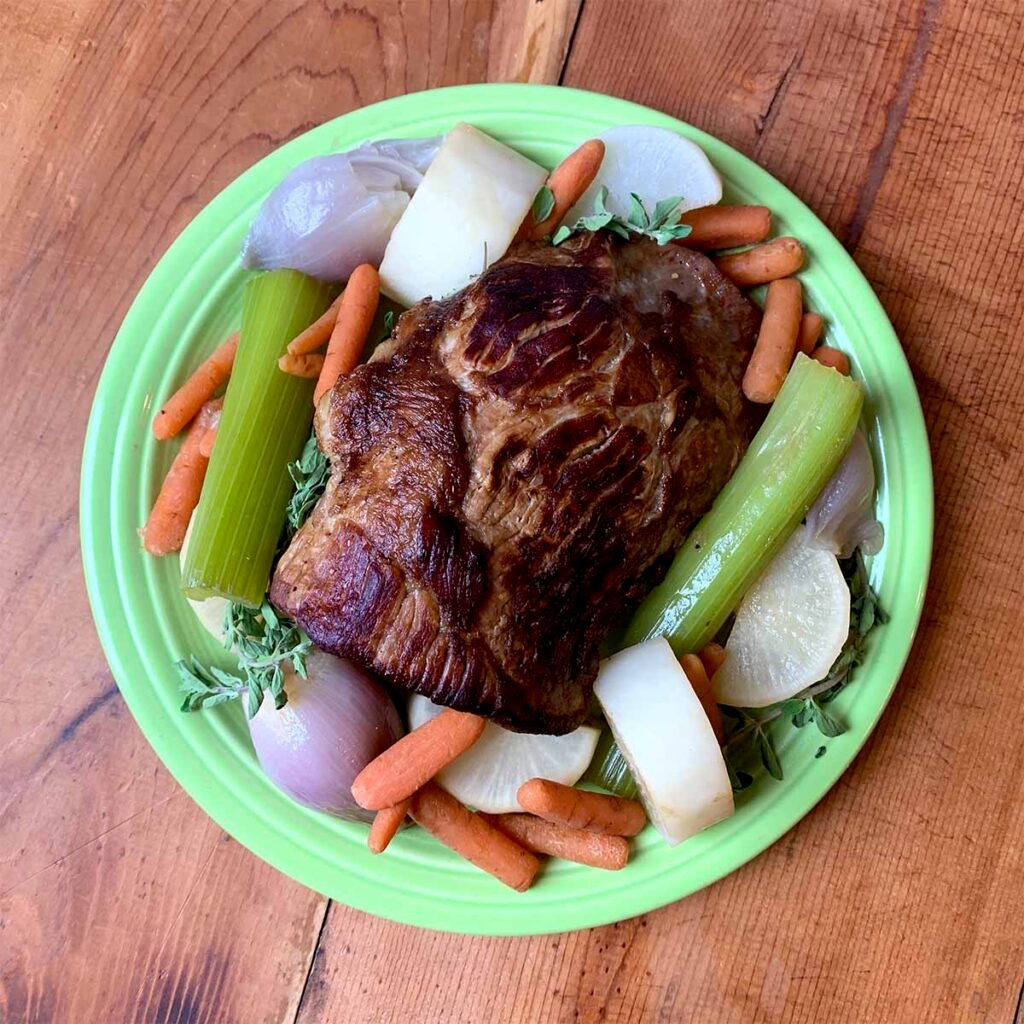 a paleo pot roast on a green platter with vegetables