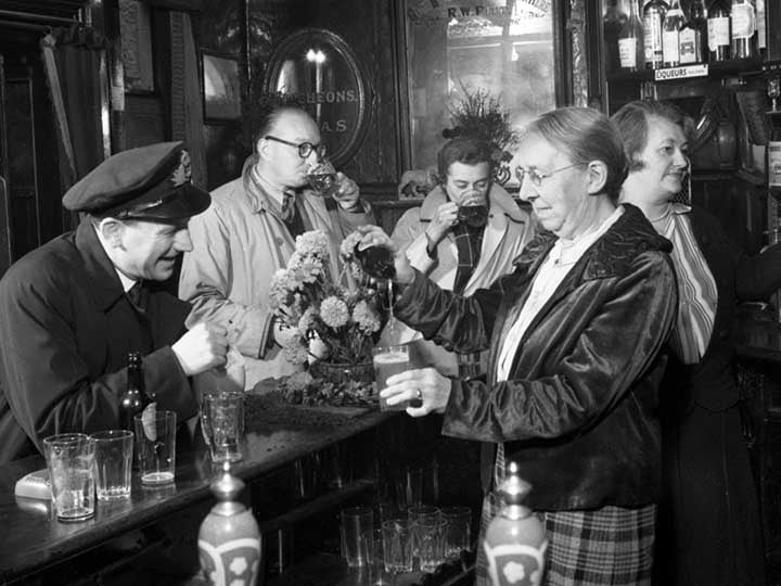 a black and white photograph of people in a bar