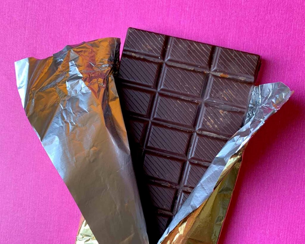 a low carb Candy Bar against a pink background