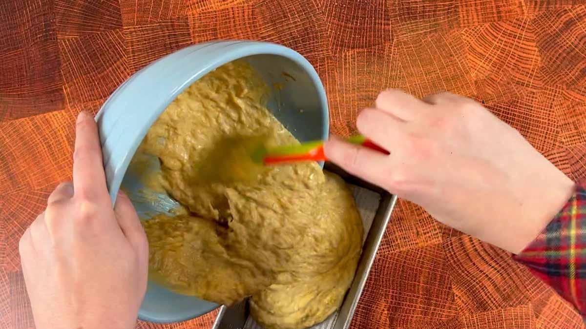 batter being poured into a loaf pan