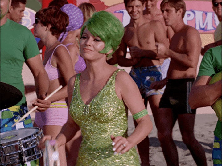 a vintage 1950's photo of a woman dancing in a green sparkly swimsuit