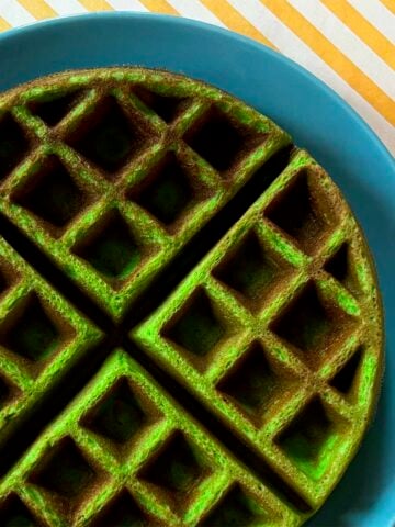 a Pandan Waffle on a blue plate against a yellow striped background