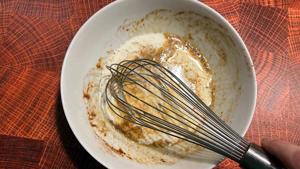 a whisk mixing the custard