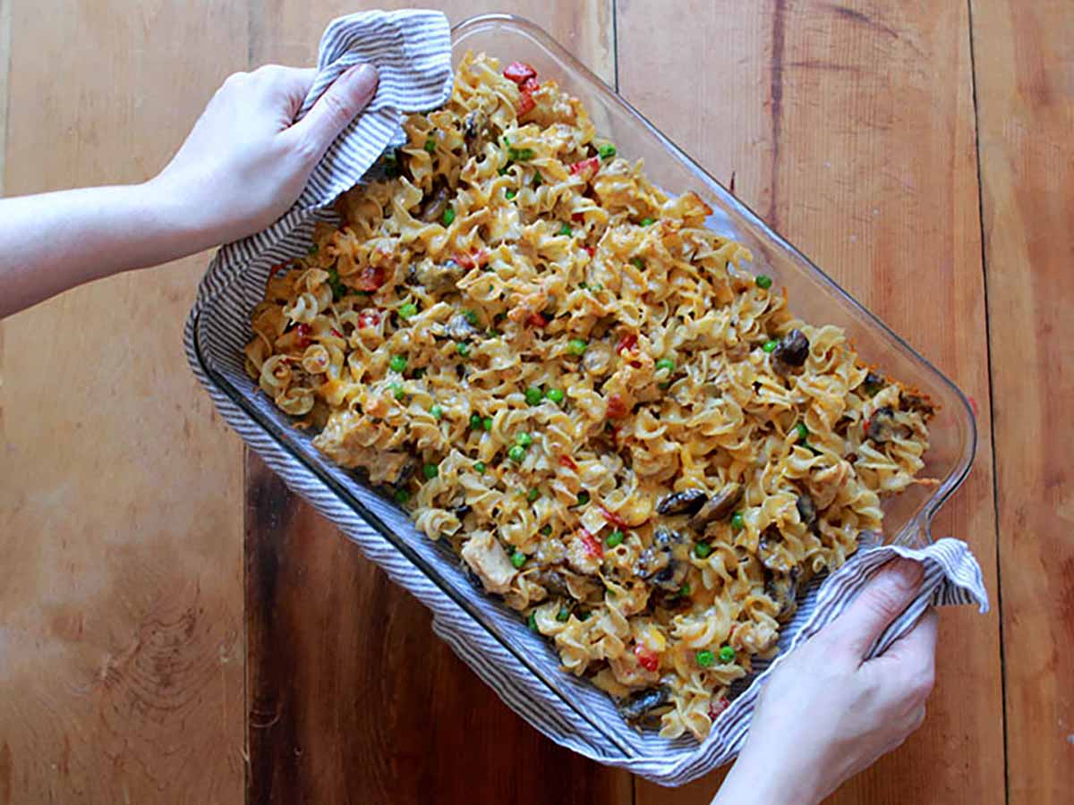 2 hands hold a low carb Tuna Noodle Casserole.